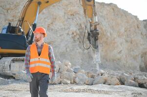 Portrait of a worker standing on the background of a stone quarry photo
