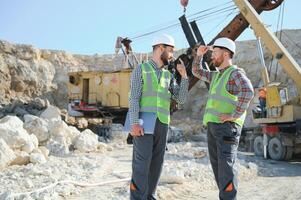 Two workers and quarry in background photo