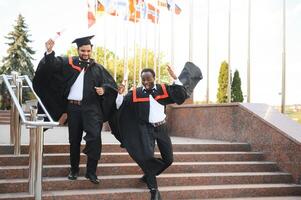 Group of multiracial graduate students with diplomas on university background photo
