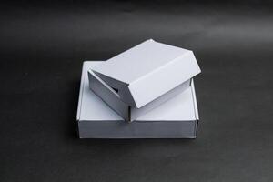 Two boxes are stacked on top of each other and The top box is slightly open photo