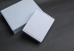 Two white boxes sitting next to each other The larger box is lying flat while the smaller box is partially on top of it photo