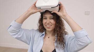 Young woman in VR glasses using modern technology creating room design, moving hands in air, standing in new apartment during renovation. Virtual reality and repair concept video