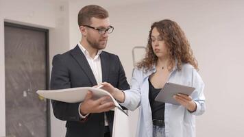 A young designer discusses the plans and design of the room with the customer. The concept of repair on a modern design video