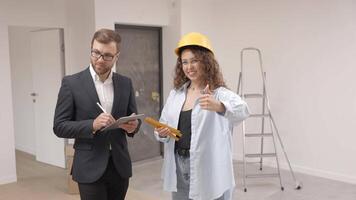A young businessman is holding a tablet and looking at the modeling of an apartment video