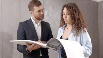 A young designer discusses the plans and design of the room with the customer. The concept of repair on a modern design video