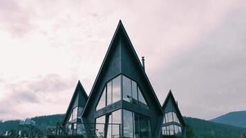 Aerial view Modern A-Frame Houses with Expansive Glass Windows Under Cloudy Sky video