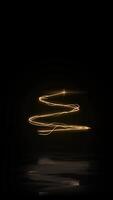 Vertical Elegant Golden Christmas Tree and Fireworks 4K Loop features a golden spiral animate on screen to form a Christmas Tree with a star, glitter, and fireworks on black in a vertical ratio loop. video