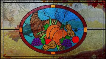 Stained Glass Thanksgiving Sunny Fall Day 4K Loop features a stained-glass window with a picture of a horn of plenty with a fall scene through the window with leaves falling in a loop. video