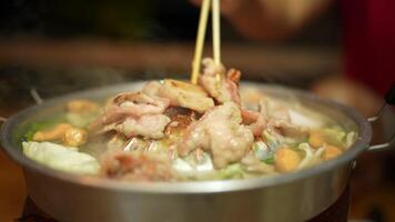 Savor delicious grilled meat and vegetables on hot plate, where vibrant colors and steam create inviting atmosphere for delightful Asian cuisine dining experience. video
