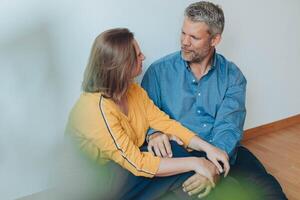 A happy couple relaxes on the floor, enjoying a playful moment in their home. photo