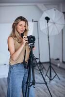 Woman photographer in a studio setting, using gear to capture creative images. photo