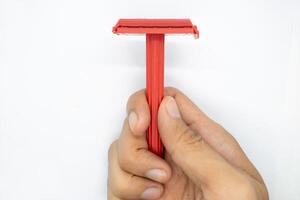 hand holding a razor on a white background photo