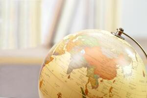 Focus globe and blur bookshelf behind. Learning, study, knowledge and education concept. photo
