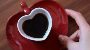 Man taking cup of coffee in shape of heart. Concept. Beautiful heart-shaped mug with coffee. Romantic mug with saucer in shape of heart with morning coffee video