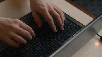 Close-up of man typing on keyboard. Stock footage. Man types beautifully with his hands on laptop keyboard. Man is working on laptop and typing on keyboard in cafe video