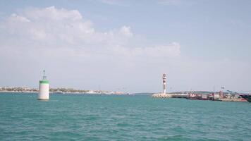 Marine port, harbor and and lighthouse on a blue cloudy sky background. Action. Cruise ships and ferry boats in Mediterranean sea. video