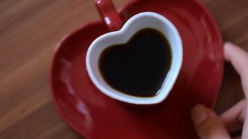 Man taking cup of coffee in shape of heart. Concept. Beautiful heart-shaped mug with coffee. Romantic mug with saucer in shape of heart with morning coffee video