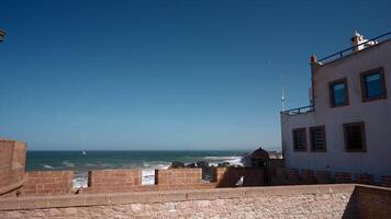A quiet house next to the ocean. Action. A small white house located on the ocean with flying seagulls around. video