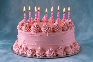 A colorful pink birthday cake with candles and sprinkles set against a bright blue background photo