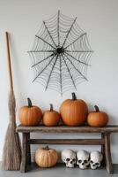 Decorative Halloween display with pumpkins, skulls, and a spider web in a cozy interior setting photo