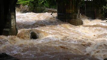 A strong current near a waterfall. Floods flowing in mountain rivers after heavy rains. Flash floods, the effects of global warming and the effects of deforestation. video