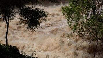 A strong current near a waterfall. Floods flowing in mountain rivers after heavy rains. Flash floods, the effects of global warming and the effects of deforestation. video