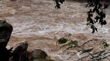 A strong current near a waterfall. Floods flowing in mountain rivers after heavy rains. Flash floods, the effects of global warming and the effects of deforestation. video