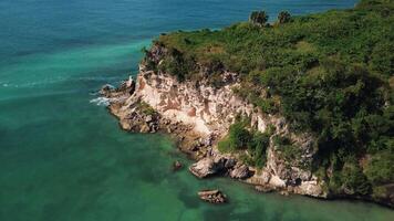 Atrial view of wild tropical coast of the Dominican Republic with rocky cliff and untouched nature.A light breeze rolls onto the shore with turquoise ocean waves.A luxurious landscape for relaxation video