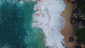 Aerial top view of the beautiful turquoise ocean waves rolling in foam on the sandy tropical beach of Atlantic Ocean along the coast of the Dominican Republic.Beauty is in the minimalism of nature. video