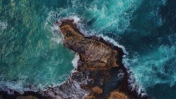 Aerial top view of coral rock washed by turquoise ocean waves in a storm. Powerful turquoise waves crashing against the rocks with thousands of sparkling splashes.Concept of tourism,travel,recreation. video