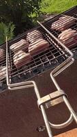 vertical pov barbecue grate with pieces of meat is turned over video