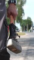 vertical close-up of a man in overalls carrying a sledgehammer in his hand video