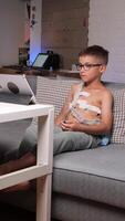 vertical boy with portable ECG Holter monitor watches on tablet video