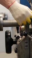 vertical close-up man worker at a lathe starting to work. Starting a lathe video