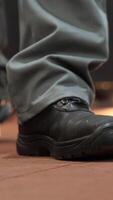 vertical close-up of the legs of a worker, mechanic, builder at a factory video