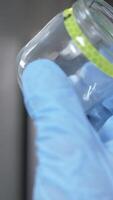 vertical Manual inspection of glass jar for defects. quality control video
