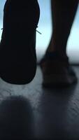 An upclose view of a runners shoe placed against the textured surface of a track video