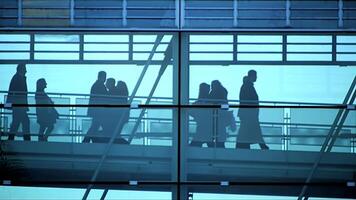Silhouetted Figures Walking Through Elegant Glass Architecture in a City Setting Today video
