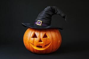 Carved Pumpkin Wearing a Witch Hat on a Black Background photo