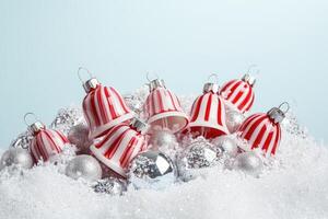 Red and White Striped Christmas Bells in Snowy Background photo