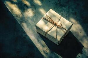 A Gift Box Tied with Twine in Sunlight on a Textured Surface photo