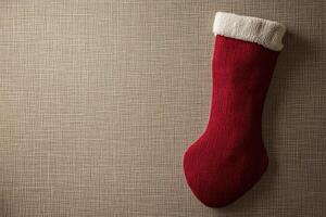Red Christmas Stocking with White Fur Trim on a Brown Fabric Background photo