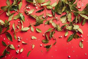 Scattered Green Leaves and White Berries on a Red Background photo