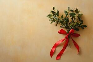 Mistletoe Sprig Tied with Red Ribbon on Beige Background photo