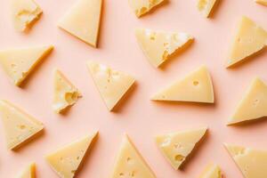 Triangular Pieces of Swiss Cheese on a Pink Background photo