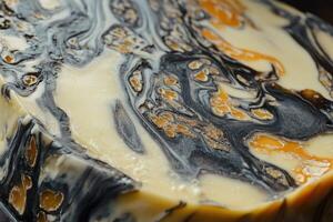Close-up of a Marbled Stone with Black, White, and Amber Hues photo