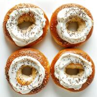 A collection of glazed and sesame seed doughnuts, arranged in a grid pattern on a white surface. photo