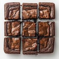 A collection of square chocolate brownies with different toppings arranged in a grid. photo