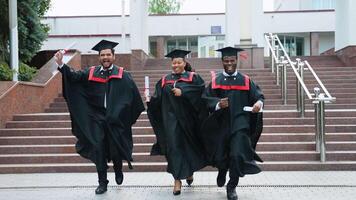 Multiracial diverse graduates are celebrating graduation, graduates running in campus video
