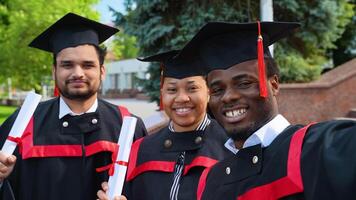 Portrait of a group of students taking selfies on graduation day video
